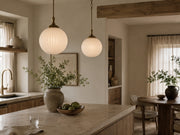 Maren ribbed opal glass pendant lights above a warm stone island