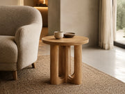 Aris round oak side table in a quiet residential reading area